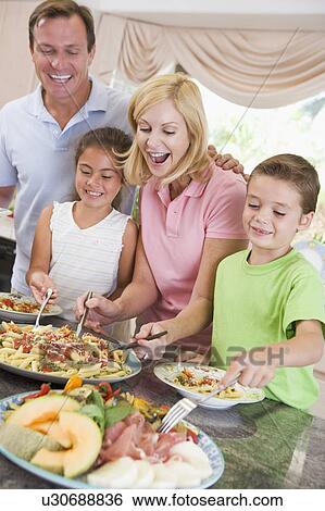 Mother Serving Up Dinner For Family View Large Photo Image Stock Photograph - Mother Serving Up Dinner For Family. Fotosearch
