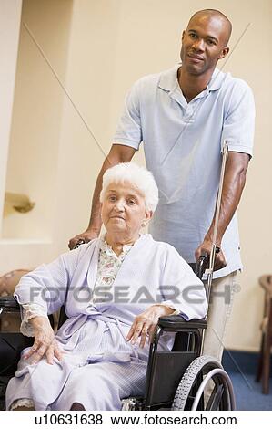 Stock Photo - Nurse Pushing Senior Woman In Wheelchair. Fotosearch