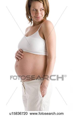 Pregnant woman holding exposed belly smiling View Large Photo Image Stock Image - Pregnant woman holding exposed belly smiling. Fotosearch