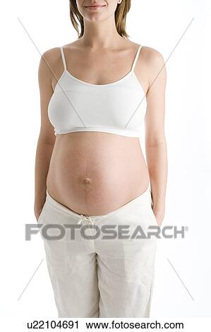 Pregnant woman with exposed belly smiling View Large Photo Image Stock Image - Pregnant woman with exposed belly smiling. Fotosearch