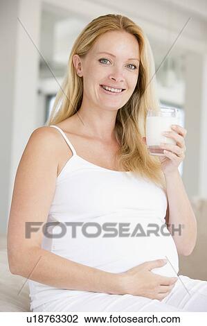 Pregnant woman with glass of milk smiling View Large Photo Image Stock Image - Pregnant woman with glass of milk smiling. Fotosearch