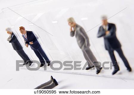 Stock Photography - Row Of Businessman Figurines, With One Fallen Out Of Line. Fotosearch