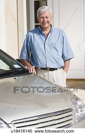 Senior man standing with his car outside his home View Large Photo Image Stock Image - Senior man standing with his car outside his home. Fotosearch