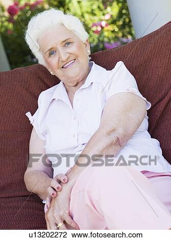 Senior woman sitting outdoors on a chair View Large Photo Image Stock Image - Senior woman sitting outdoors on a chair. Fotosearch