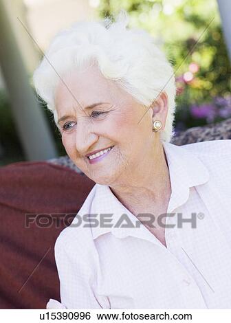 Senior woman sitting outdoors on a chair View Large Photo Image Stock Photograph - Senior woman sitting outdoors on a chair. Fotosearch