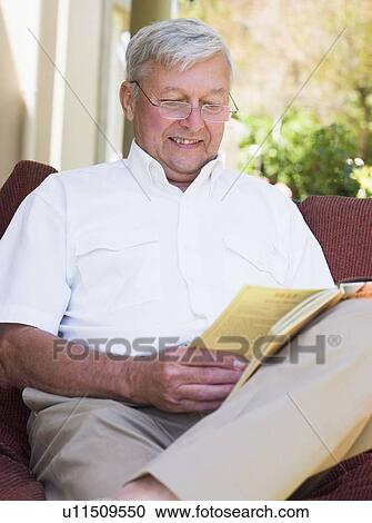 Senior woman sitting outdoors on a chair reading a book View Large Photo Image Stock Image - Senior woman sitting outdoors on a chair reading a book. Fotosearch