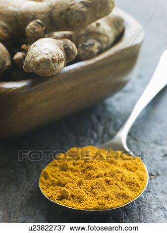 Stock Photo - Spoon of Turmeric Powder with fresh Turmeric Root. Fotosearch