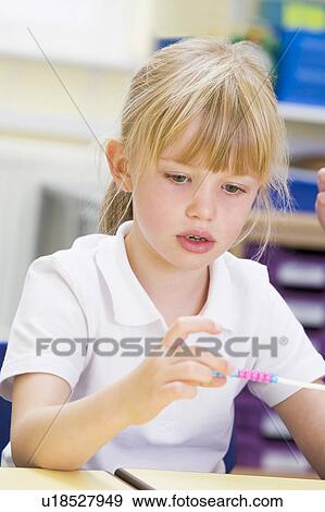 Stock Photo - Student in math class with counting beads. Fotosearch