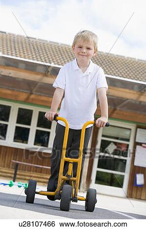 Student outside school on tricycle scooter View Large Photo Image Stock Photograph - Student outside school on tricycle scooter. Fotosearch