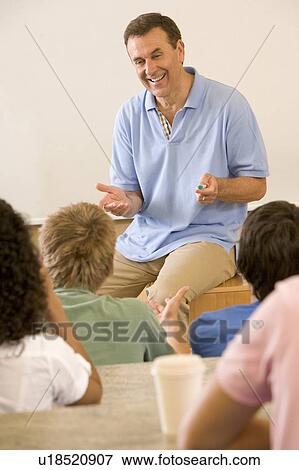 Stock Photo - Teacher giving lecture to students in classroom (selective focus). Fotosearch