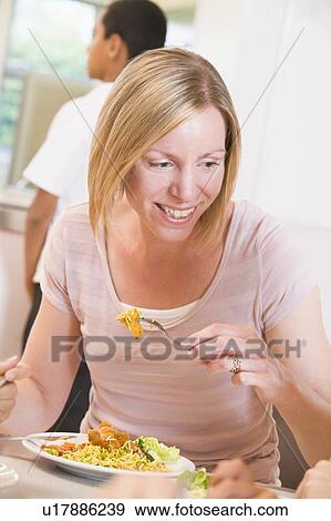 Teacher sitting at cafeteria table eating lunch View Large Photo Image Stock Photo - Teacher sitting at cafeteria table eating lunch. Fotosearch