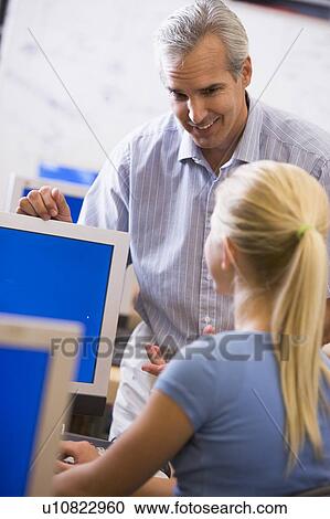 Teacher with female student in computer class View Large Photo Image Stock Image - Teacher with female student in computer class. Fotosearch