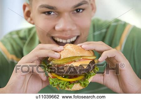 Teenage Boy Eating Burger View Large Photo Image Stock Image - Teenage Boy Eating Burger. Fotosearch