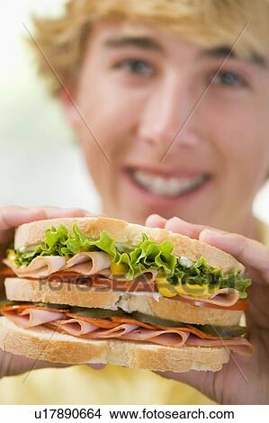 Picture - Teenage Boy Eating Sandwich. Fotosearch