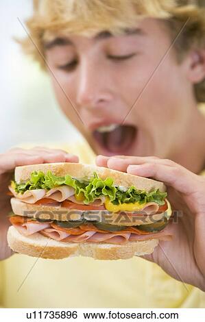 Stock Photograph - Teenage Boy Eating Sandwich. Fotosearch