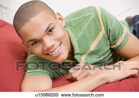 Stock Image - Teenage Boy Lying On Bed. Fotosearch
