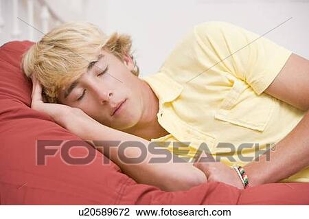 Stock Image - Teenage Boy Lying On Bed. Fotosearch