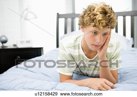 Stock Photo - Teenage Boy Lying On Bed. Fotosearch