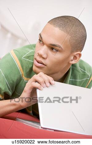 Teenage Boy Lying On Bed Using Laptop View Large Photo Image Stock Image - Teenage Boy Lying On Bed Using Laptop . Fotosearch