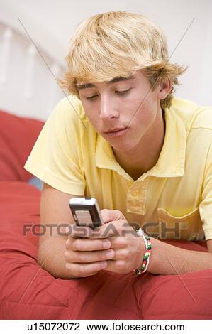 Teenage Boy Lying On Bed Using Mobile Phone View Large Photo Image Stock Image - Teenage Boy Lying On Bed Using Mobile Phone . Fotosearch