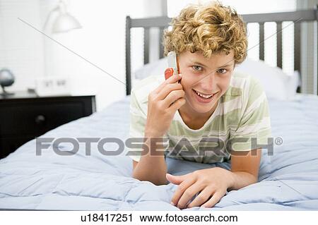 Teenage Boy Lying On Bed Using Mobile Phone View Large Photo Image Stock Image - Teenage Boy Lying On Bed Using Mobile Phone . Fotosearch