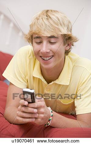 Teenage Boy Lying On Bed Using Mobile Phone View Large Photo Image Stock Image - Teenage Boy Lying On Bed Using Mobile Phone . Fotosearch