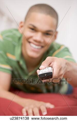 Teenage Boy Lying On Bed Using Remote View Large Photo Image Stock Photo - Teenage Boy Lying On Bed Using Remote. Fotosearch