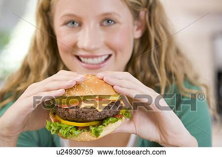 Stock Photo - Teenage Girl Eating Burgers . Fotosearch