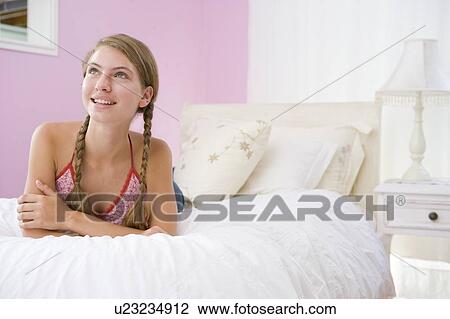 Stock Image - Teenage Girl Lying On Bed. Fotosearch