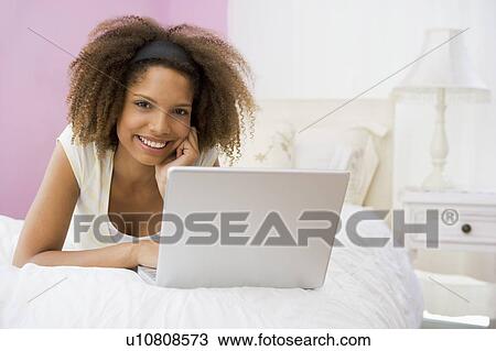 Teenage Girl Lying On Bed Using Laptop View Large Photo Image Stock Image - Teenage Girl Lying On Bed Using Laptop . Fotosearch
