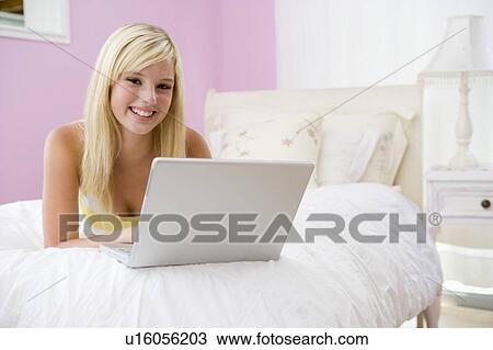 Teenage Girl Lying On Bed Using Laptop View Large Photo Image Stock Image - Teenage Girl Lying On Bed Using Laptop . Fotosearch
