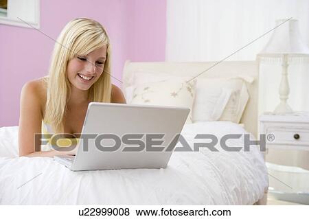Teenage Girl Lying On Bed Using Laptop View Large Photo Image Stock Photo - Teenage Girl Lying On Bed Using Laptop . Fotosearch