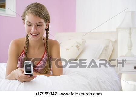 Teenage Girl Lying On Bed Using Mobile Phone View Large Photo Image Stock Image - Teenage Girl Lying On Bed Using Mobile Phone . Fotosearch