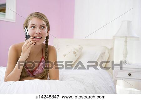 Teenage Girl Lying On Bed Using Mobile Phone View Large Photo Image Stock Photo - Teenage Girl Lying On Bed Using Mobile Phone . Fotosearch