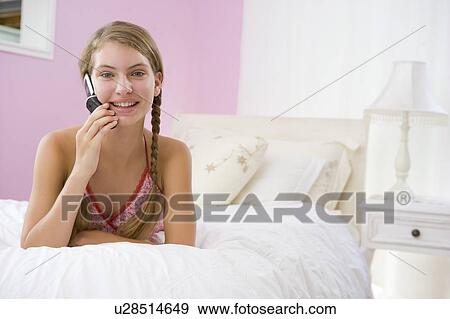 Teenage Girl Lying On Bed Using Mobile Phone View Large Photo Image Stock Photo - Teenage Girl Lying On Bed Using Mobile Phone . Fotosearch