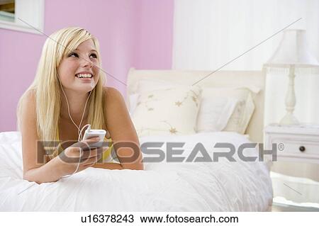 Teenage Girl Lying On Bed Using Mp3 Player View Large Photo Image Stock Image - Teenage Girl Lying On Bed Using Mp3 Player. Fotosearch