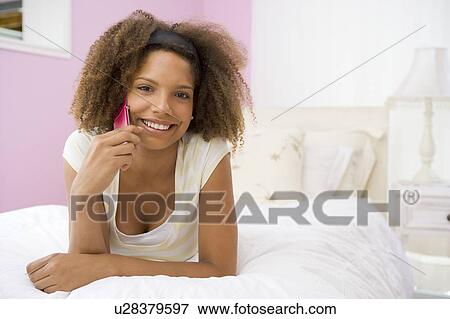 Teenage Girl Lying On Bed Using Cellphone View Large Photo Image Stock Photo - Teenage Girl Lying On Bed Using Cellphone. Fotosearch