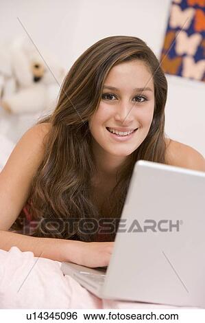 Teenage Girl Lying On Her Bed Using Laptop View Large Photo Image Stock Photograph - Teenage Girl Lying On Her Bed Using Laptop. Fotosearch