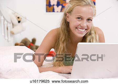 Teenage Girl Lying On Her Bed Using Laptop View Large Photo Image Stock Photography - Teenage Girl Lying On Her Bed Using Laptop. Fotosearch