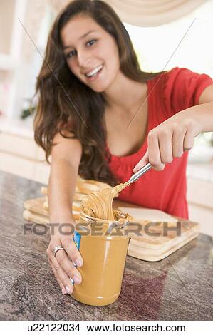 Picture - Teenage Girl Making Peanut Butter Sandwich. Fotosearch