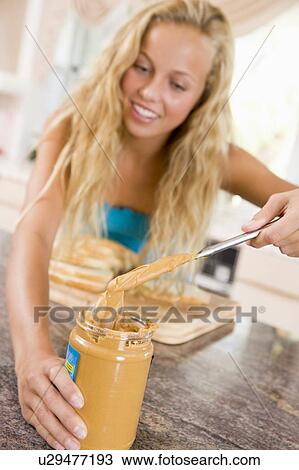 Stock Image - Teenage Girl Making Peanut Butter Sandwich. Fotosearch