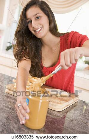 Stock Photography - Teenage Girl Making Peanut Butter Sandwich. Fotosearch
