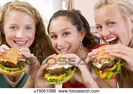 Stock Photo - Teenage Girls Eating Burgers . Fotosearch