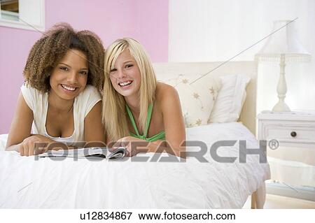 Teenage Girls Lying On Bed View Large Photo Image Stock Photo - Teenage Girls Lying On Bed. Fotosearch