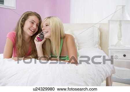 Teenage Girls Lying On Bed Using Cell Phone View Large Photo Image Stock Image - Teenage Girls Lying On Bed Using Cell Phone . Fotosearch