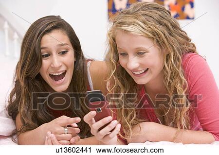 Teenage Girls Lying On Bed Using Mobile Phone View Large Photo Image Stock Image - Teenage Girls Lying On Bed Using Mobile Phone. Fotosearch