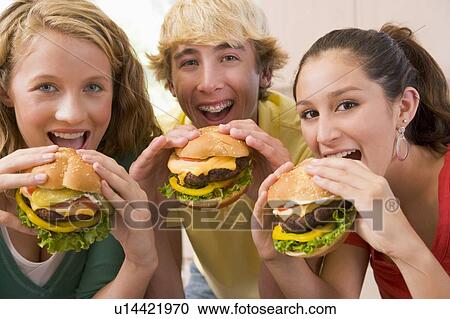 Stock Image - Teenagers Eating Burgers. Fotosearch