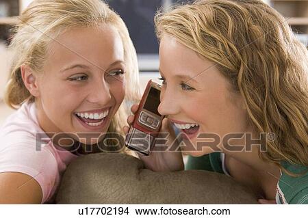 Teenagers Hanging Out In Front Of Television Using Mobile Phones View Large Photo Image Picture - Teenagers Hanging Out In Front Of Television Using Mobile Phones . Fotosearch