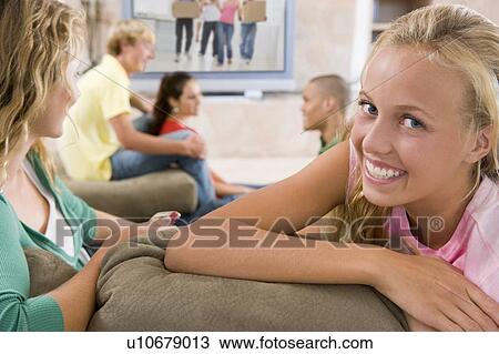 Stock Image - Teenagers Hanging Out In Front Of Television . Fotosearch