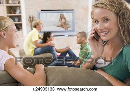 Stock Image - Teenagers Hanging Out In Front Of Television . Fotosearch